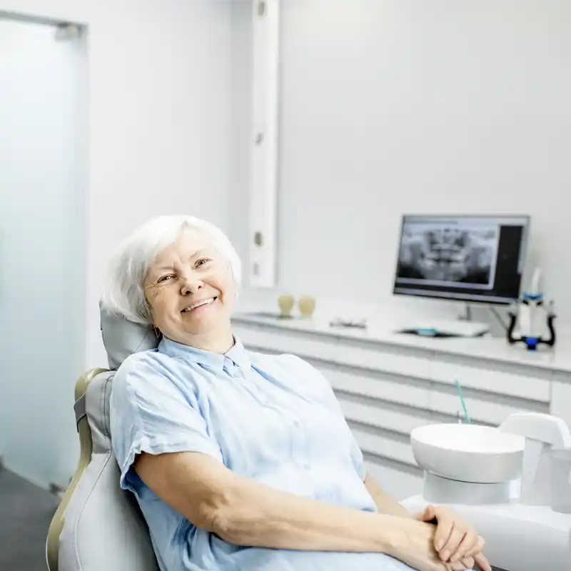  An older woman smiling before her dental appointment in the chair